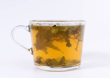 Beyaz arka planda izole şeffaf bir bardak yeşil bitkisel çay