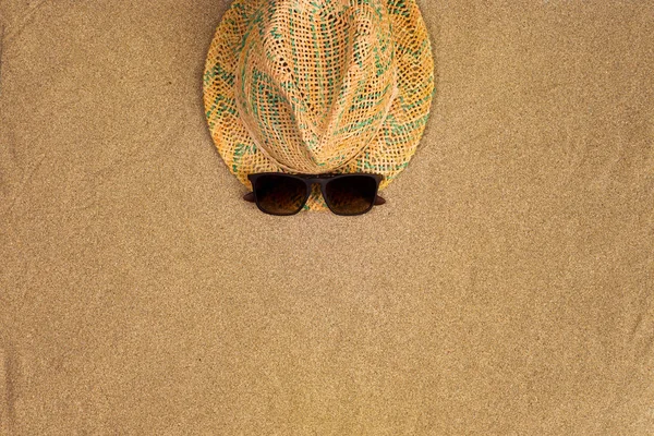 Minimalist summer flat lay with, sunglasses and panama hat on sand background