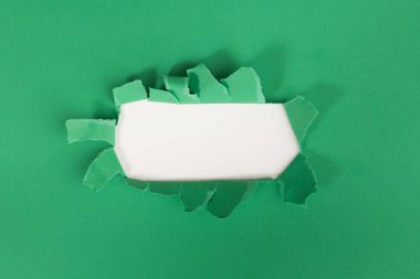 yeşil arka plan üzerinde yırtık kağıt yırtık yırtık Delik