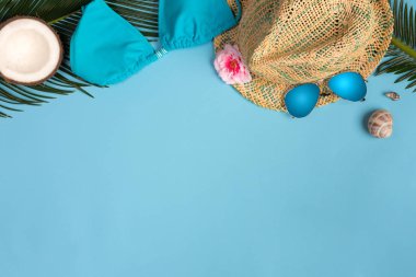 Plaj hazır, pastel mavi arka plan üzerinde yaz tatili tatil aksesuarları. Mayo, şapka ve güneş gözlüğü