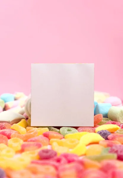 Sweets and a blank sheet on a pink background.