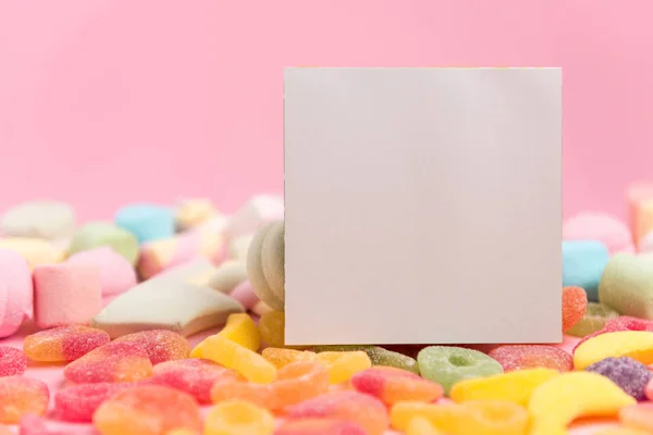 Sweets and a blank sheet on a pink background.
