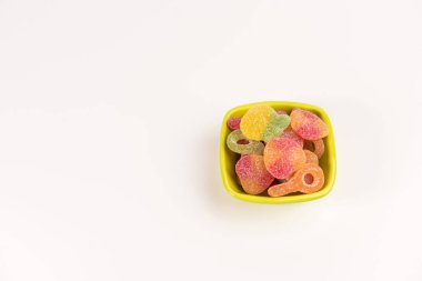 Beyaz arka plan üzerinde izole sakızlı şekerler ile küçük bir kase. Üstte görüntü.