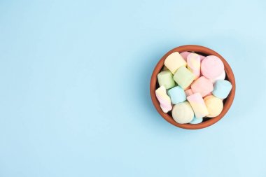 Yuvarlak bir kapta Marshmallows, mavi arka plan üzerinde izole. Üstte görüntü.