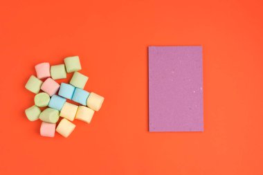 Marshmallow ve not defteri ile Mercan kağıt arka plan. Metniniz için yerleştirin. Rahat tatlı arka plan