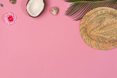Pastel pembe renk arka plan üzerinde hindistan cevizi, deniz kabukları, palmiye yaprakları ve panama şapka ile Yaratıcı Düz yatıyordu moda tarzı