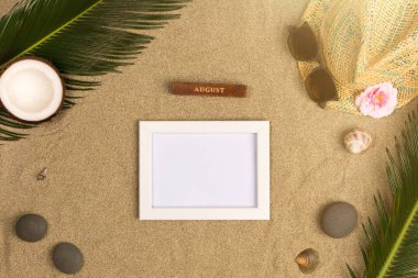 Fotoğraf çerçevesi, yeşil yaprakları, şapka ve kum arka plan üzerinde güneş gözlüğü ile şık yaz kompozisyon. Kopya alanı ile sanat mockup