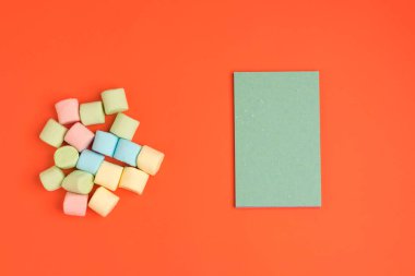 Marshmallow ve not defteri ile Mercan kağıt arka plan. Metniniz için yerleştirin. Rahat tatlı arka plan