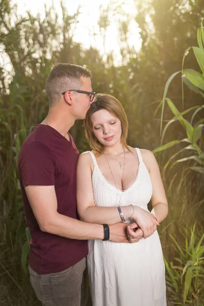 夏の公園で愛する男性と幸せな妊娠中の女性 屋外を抱きしめる愛の幸せな成熟したカップル — ストック写真