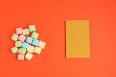 Marshmallow ve not defteri ile Mercan kağıt arka plan. Metniniz için yerleştirin. Rahat tatlı arka plan