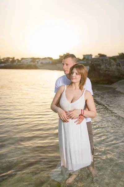 Kobieta Ciąży Obejmując Męża Plaży Zachodzie Słońca — Zdjęcie stockowe