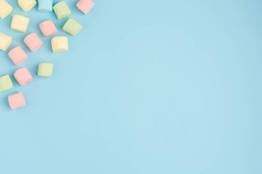 Mavi renkli arka planda marshmallow. Rahat tatlı arka plan
