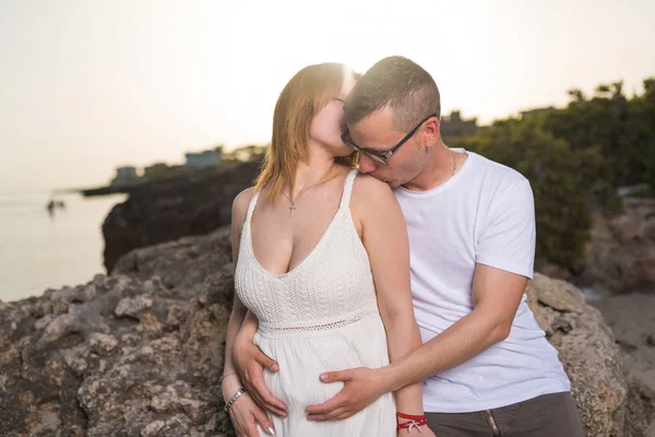 Νεαρό Ζευγάρι Έγκυος Στην Παραλία Ηλιοβασίλεμα Άνθρωπος Αγκαλιάζει Την Έγκυο — Φωτογραφία Αρχείου