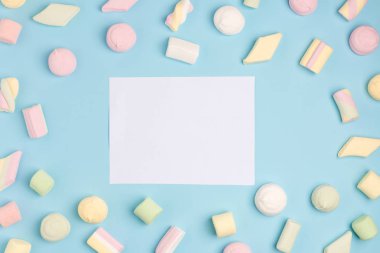 Marshmallow ve Notepad ile mavi Kağıt arka plan. Metniniz için yerleştirin. Rahat tatlı arka plan