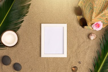 Fotoğraf çerçevesi, yeşil yaprakları, şapka ve kum arka plan üzerinde güneş gözlüğü ile şık yaz kompozisyon. Kopya alanı ile sanat mockup