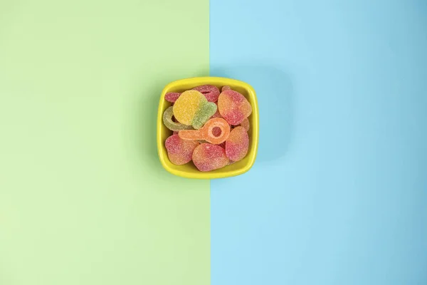 Kleine Schüssel Mit Gummibonbons Isoliert Auf Grünem Und Blauem Hintergrund — Stockfoto