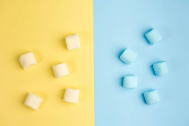 Mavi ve sarı arka planlar üzerinde Marshmallow. İki renk. Üst görünüm.