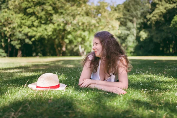 夏の公園で 草の上に横たわっている若い 魅力的な女性の肖像画 — ストック写真