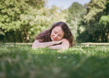 Genç, sevimli kadın yaz parkında rahatlatıcı. Açık yaşam tarzı.