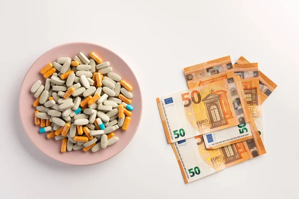 A plate with pills and money isolated on white background