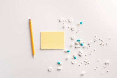 Not defteri, kalem ve haplar beyaz arka plan üzerinde. Tıbbi konsept. Düz yatıyordu.