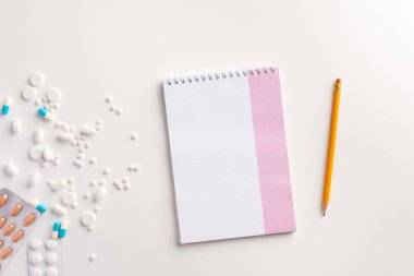 Haplar, kalem ve beyaz arka plan üzerinde defter. Tıbbi konsept. Düz yatıyordu.