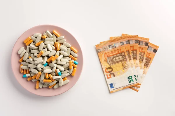 A plate with pills and money isolated on white background