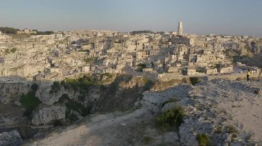 Matera, İtalya'nın havadan görünümü. Uçurumun kenarında duran kadın