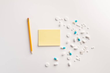 Not defteri, kalem ve haplar beyaz arka plan üzerinde. Tıbbi konsept. Düz yatıyordu.