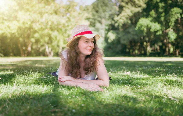 女性の屋外の肖像画 幸せな 若い女性は 夏の公園で 緑の草の上に横たわって — ストック写真