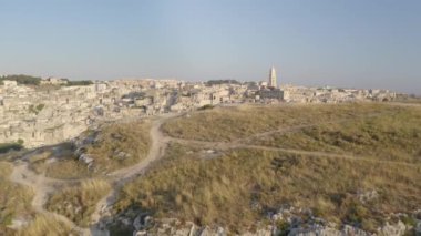 Matera, İtalya'nın havadan görünümü. Uçurumun kenarında duran kadın