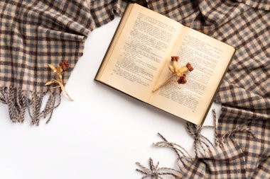 Açık kitap ve eşarp, beyaz bir arka plan üzerinde. Düz yatıyordu.