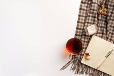 Açık defter, atkı, mum, beyaz arka plan üzerinde. Düz yatıyordu.