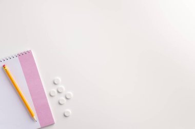 Not defteri, kalem ve haplar beyaz arka plan üzerinde. Tıbbi konsept. Düz yatıyordu.