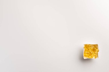 Beyaz arka plan üzerinde izole balık yağı kapsülleri ile Kase. Düz yatıyordu.