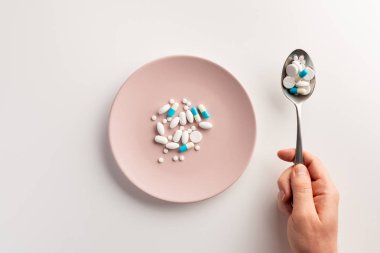 Bir kaşık hap ve haplarla tabak. Düz yatıyordu