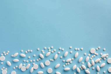 Mavi arka planda beyaz haplar. Düz yatıyordu.