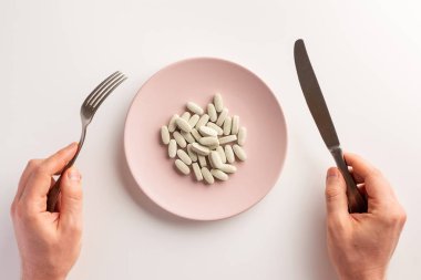 Erkek el tutan çatal ve bıçak. Diyet takviyeleri ile Plaka. Düz yatıyordu.