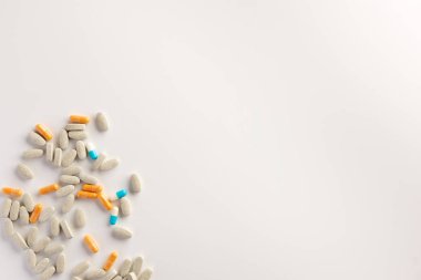 Beyaz arka plana dağılmış farklı haplar. Düz yatıyordu.