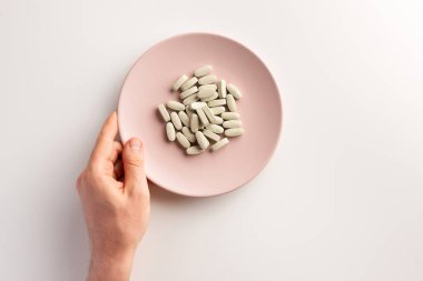 Diyet takviyeleri ile erkek el ve plaka. Düz yatıyordu.