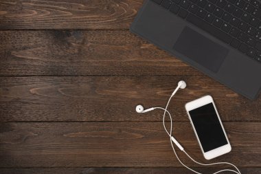 Laptop ve akıllı telefon masanın üstünde. Üst görüntü, ev konseptinde çalışma