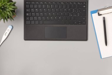 Üst kattaki ofis masasında yatıyordu. Çalışma alanı boş pano, dizüstü bilgisayar, not defteri, kalem, termometre. Tıbbi konsept