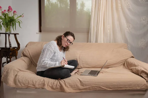 Fiatal Kanapén Nappaliban Távolról Dolgozik Otthon Laptopjával Könyveivel Dolgozik Jogdíjmentes Stock Fotók