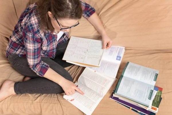 Uma Jovem Estudante Sentada Sofá Usando Livros Estudar — Fotografia de Stock