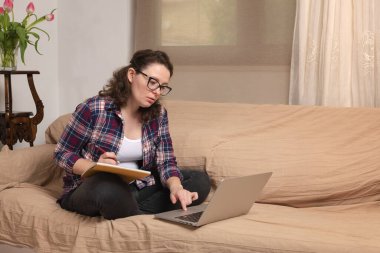 Coronavirus. Karantinaya alın. Evde eğitim, eğitim ve serbest çalışma. Yetişkin bir kadın evde bilgisayarla ve kitaplarla uzaktan çalışıyor. Dünyada koronavirüs salgını.