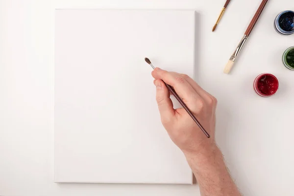 Gouache, fırçalar, beyaz arka planda beyaz tuval. Beyaz tuvale el çizimi. Uzayı kopyala Üst Manzara. Düz yatıyordu.