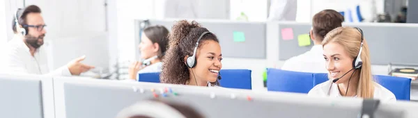 呼叫中心工作人员在她的团队的陪同下 微笑的客户支持操作员在工作 使用耳机的年轻员工 — 图库照片