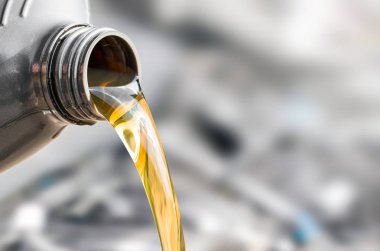 Pouring oil to car engine, close up shot clipart