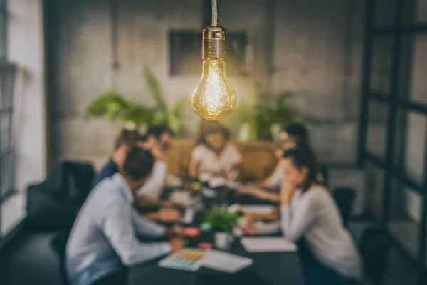 Junge Geschäftsleute Treffen Sich Schreibtisch Mit Glühender Glühbirne — Stockfoto