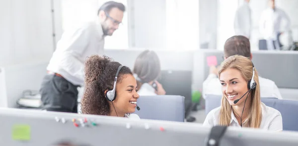 Trabalhadores Call Center Com Fones Ouvido Sorrindo Para Outro — Fotografia de Stock